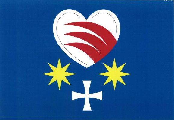 Modrý list s bílým srdcem se třemi červenými vlčími zuby. Pod srdcem bílý tlapatý kříž provázený nahoře dvěma osmicípými žlutými hvězdami. Poměr šířky k délce listu je 2 : 3.
